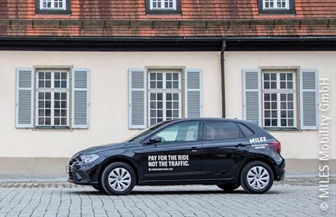 Ein schwarzes MILES Carsharing Fahrzeug steht vor den Nebengebäuden des Schloss Solitude in Stuttgart.